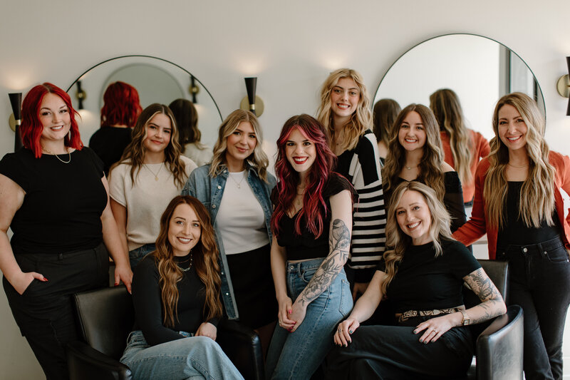 The Bob Salon team of professional stylists and colorists posing together in the salon, showcasing a friendly and welcoming atmosphere in Fort Wayne.