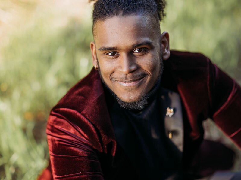 Senior portrait of a boy with a great smile and red suit.