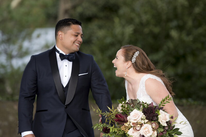A newlywed couple holding hands and laughing together 