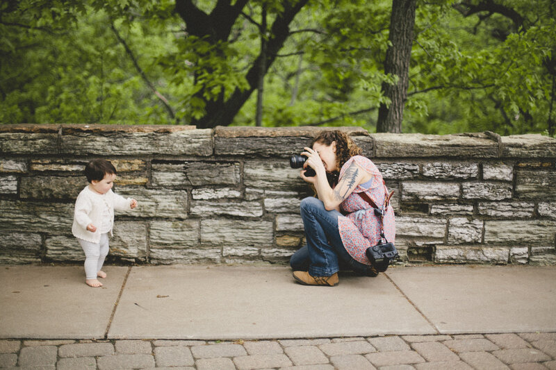 danica donnelly takes a photo of a young girl against the rock fence