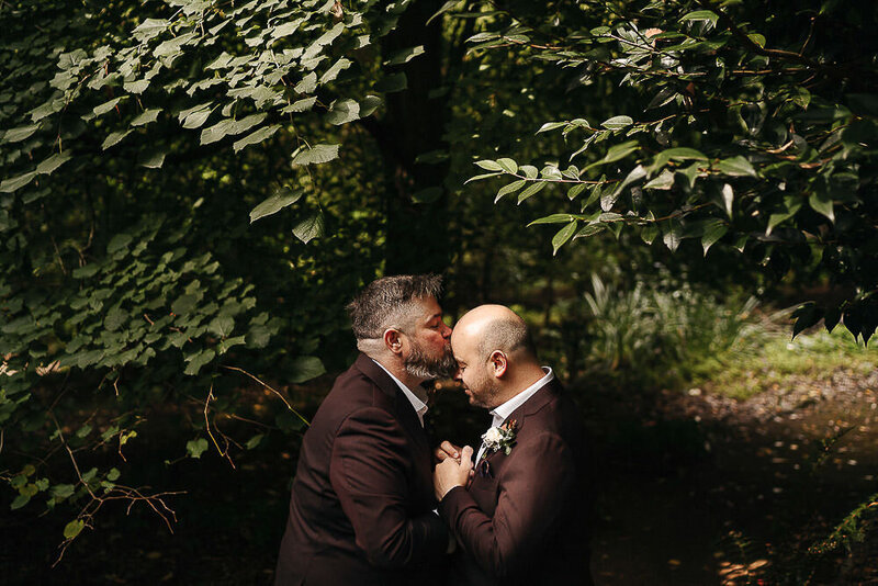 two grooms cuddled up sharing a kiss at their melbourne yarra valley wedding