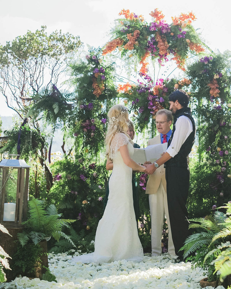 Bride + Groom hold hands as they stand at the altar