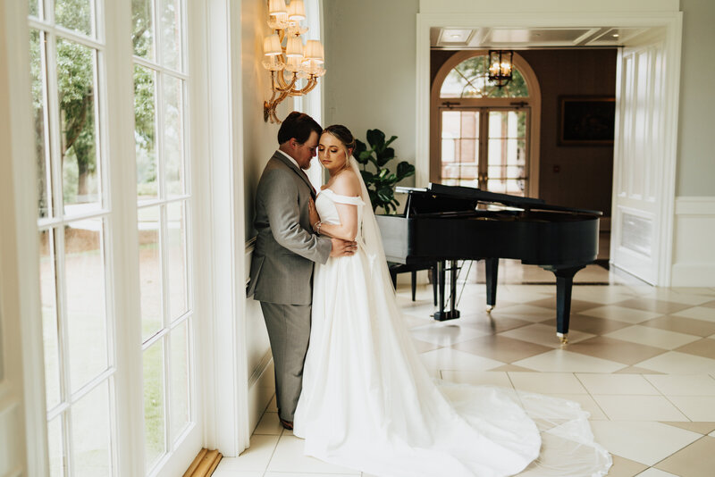 Bride & groom kissing in front of trees