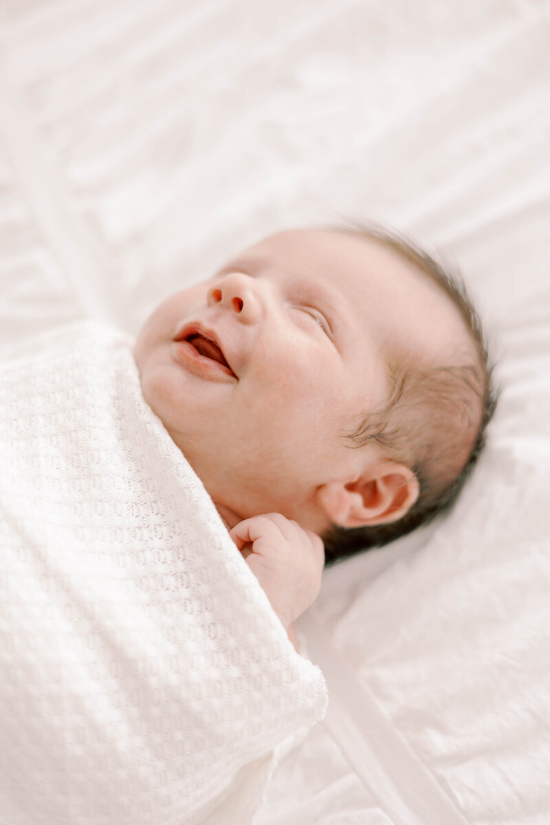 Smiling newborn baby girl taken during a Flower Mound newborn photo session. 