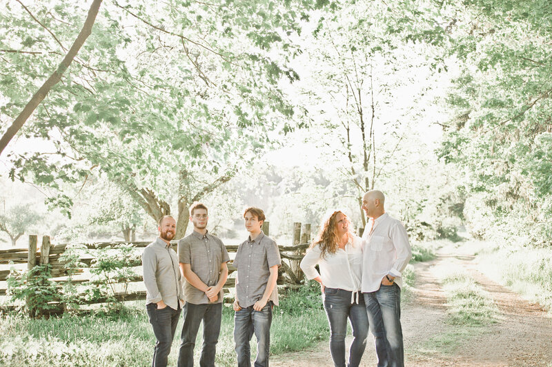 A beautiful family portrait taken in natural light beneath the trees, full of connection and warmth.