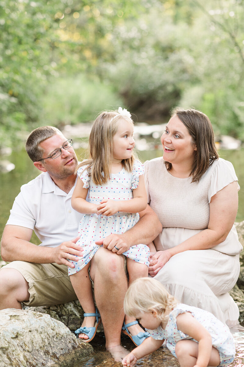 family session at harrisburg pa park by a creek with mom dad and two young daughters