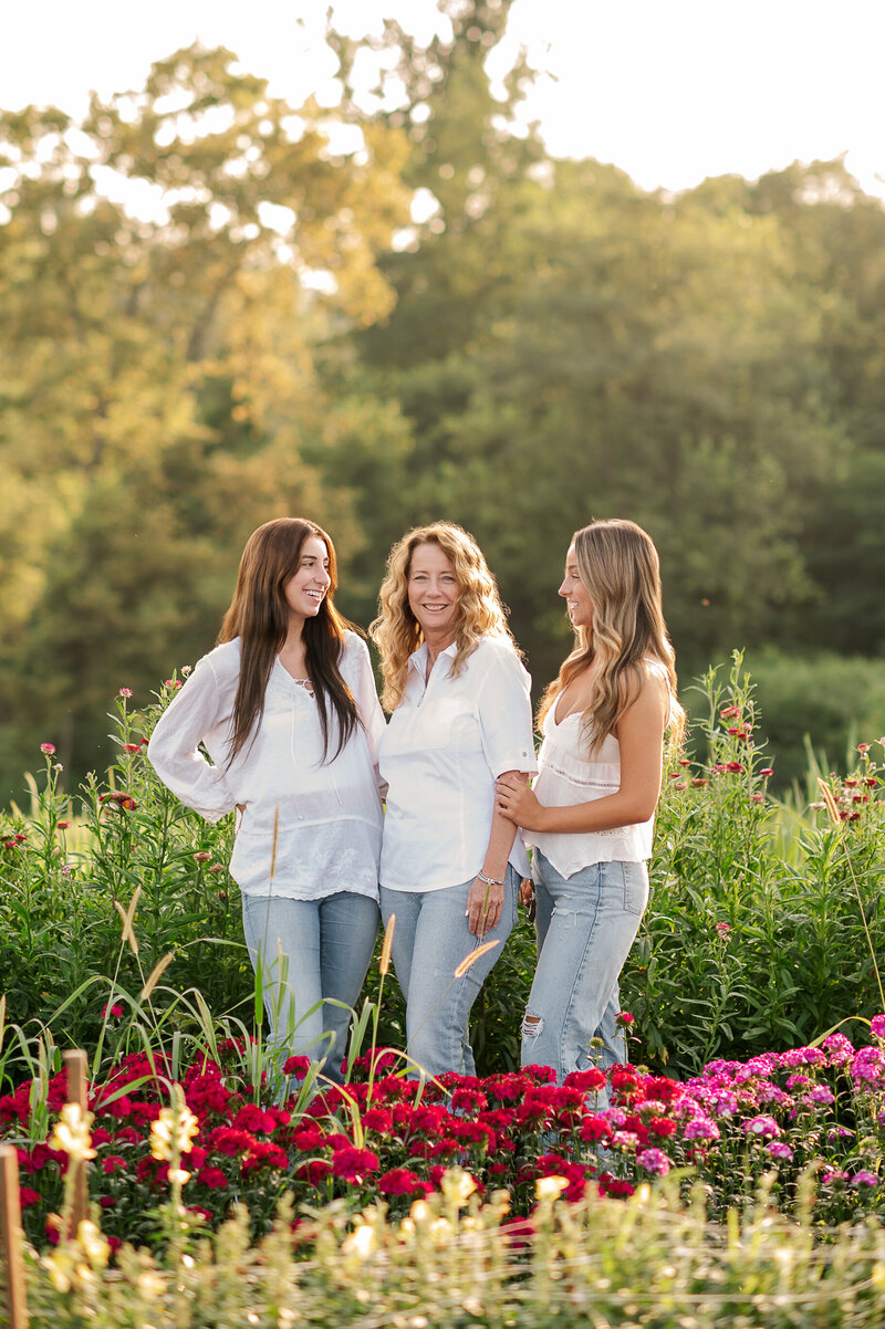 Family photographer captures mom and daughters in a blooming garden near Lancaster, PA