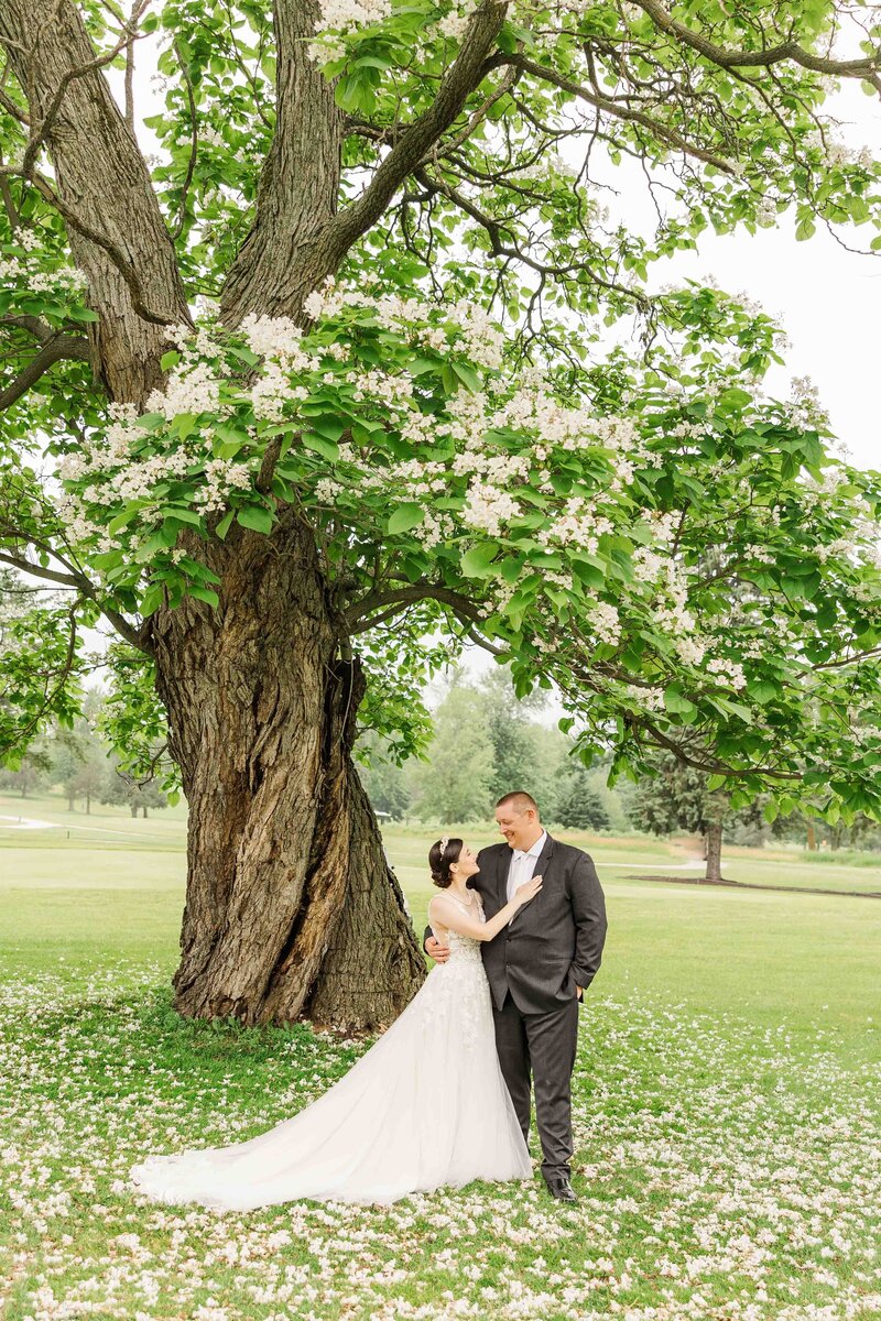 Bride and groom portrait during first look under a blooming white flower tree, Appleton Wisconsin.