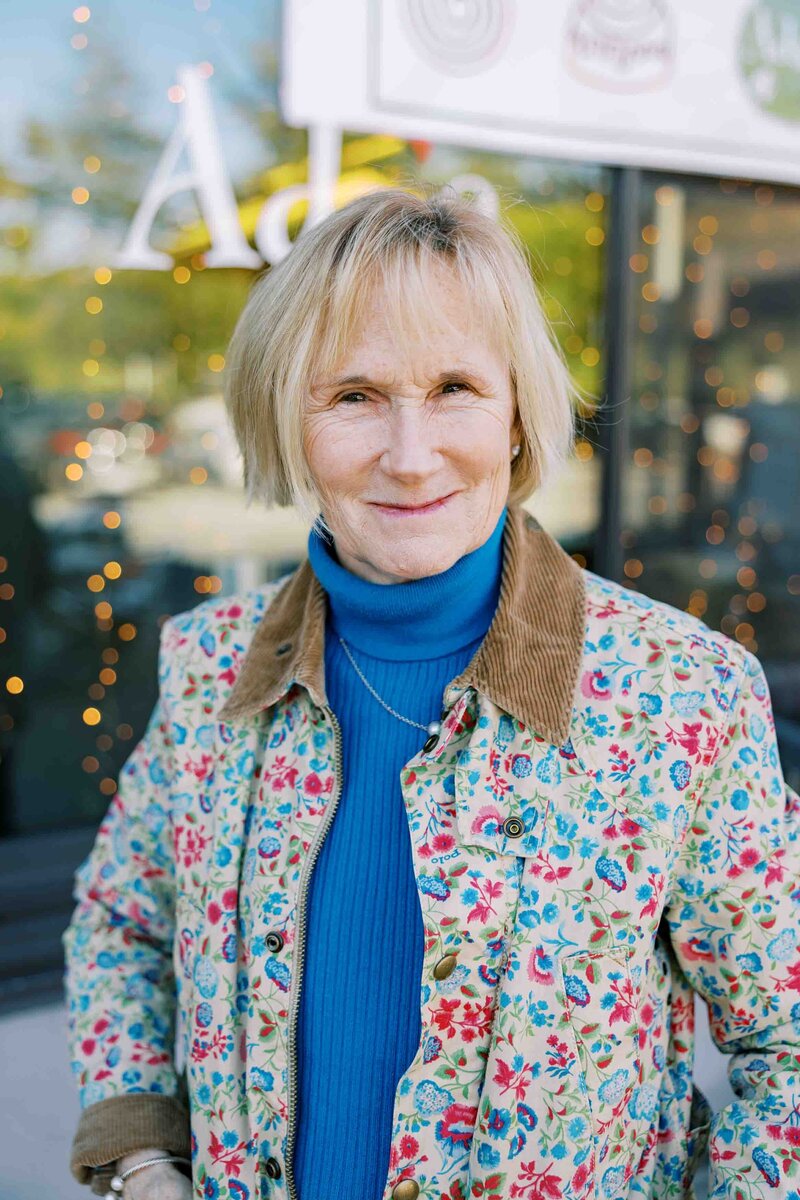 Woman wearing a floral jacket smiling at the camera