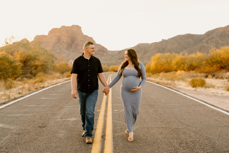 expecting couple walks down arizona road