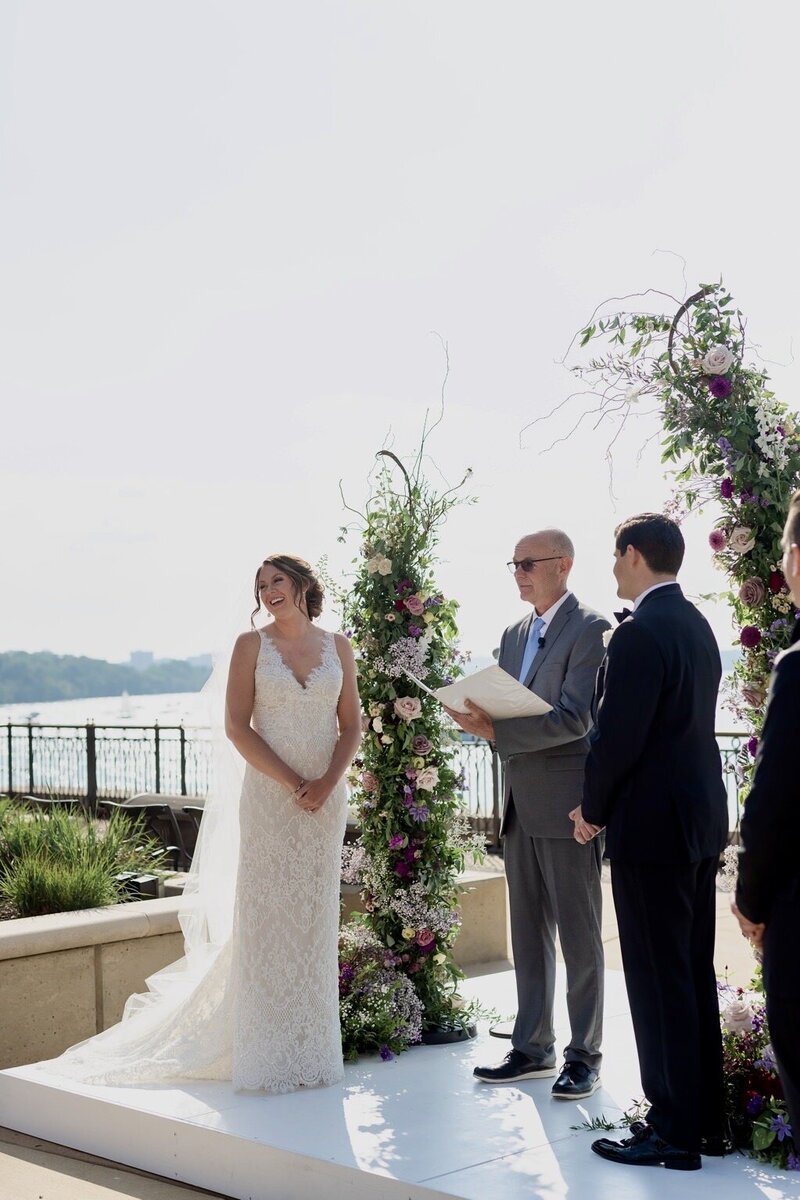 Bride and groom take their vows with wedding officiant on their wedding day
