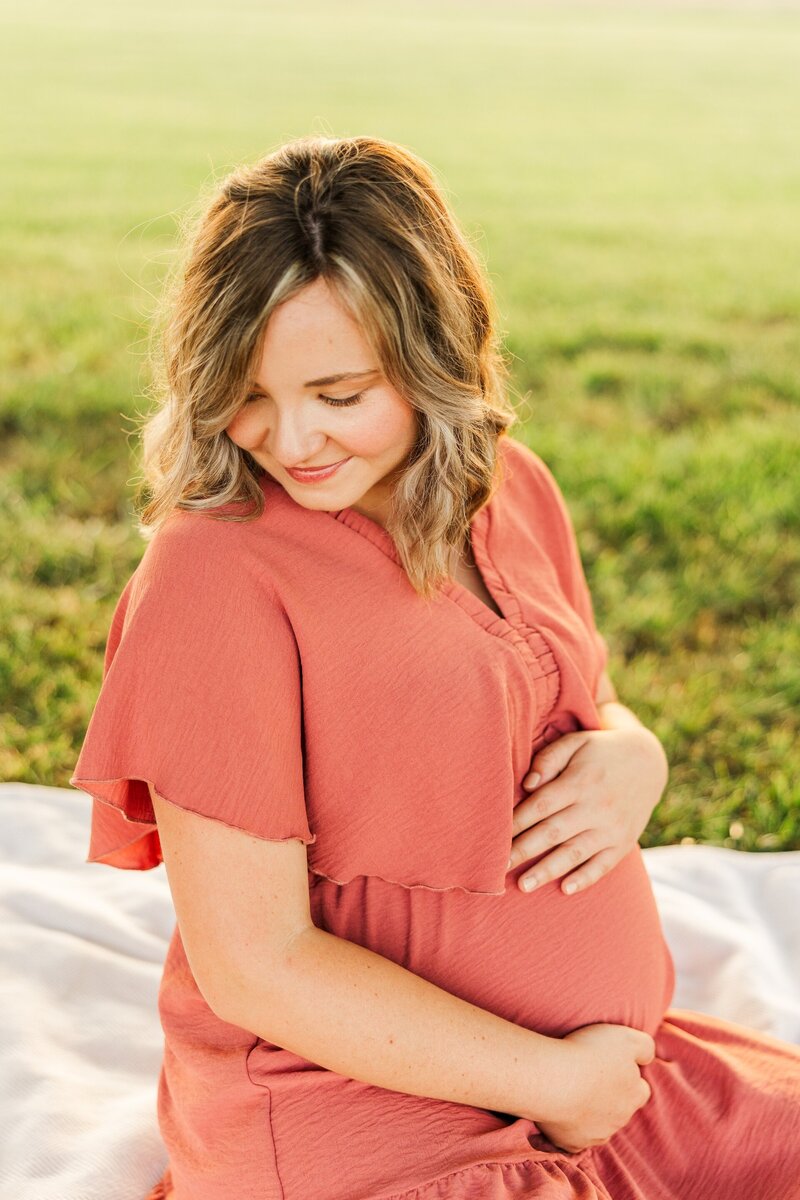 a pregnant woman posing in a pink dress