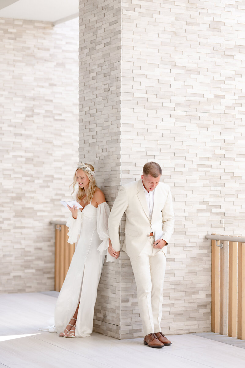 Bride and groom reading their vows in a quiet, private moment surrounded by soft light and emotion.