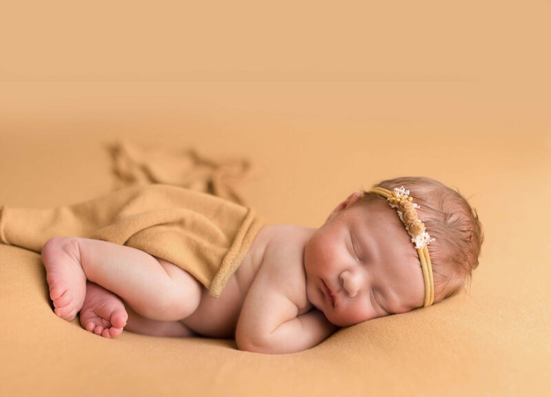 Baby girl on mustard colored backdrop woodinville studio