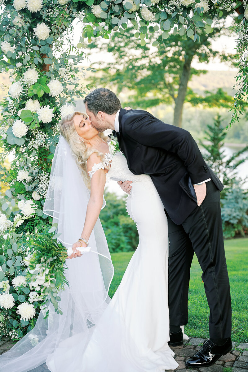 Connecticut Bride and Groom kiss in front of their Floral Altar at the Saint Clements Castle Wedding Venue, taken by New York City Wedding Photographer Corey Lamar Photography