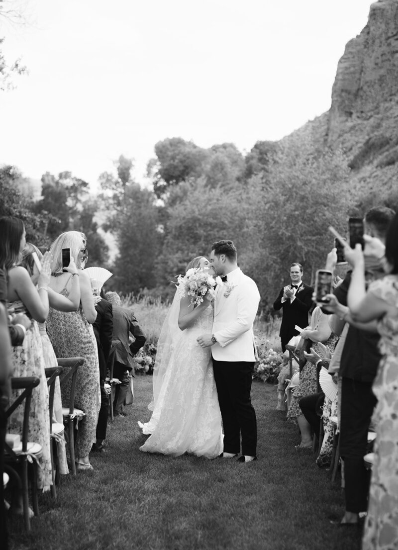 bride and groom first kiss during mountain wedding ceremony in utah
