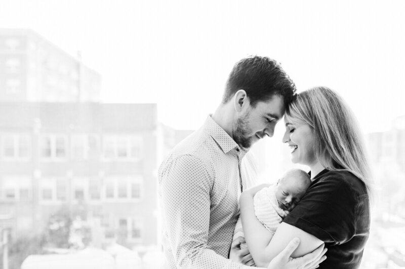 mom and dad holding baby black and white