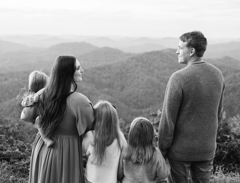 Picture of mom and dad with 3 kids staring over the mountains