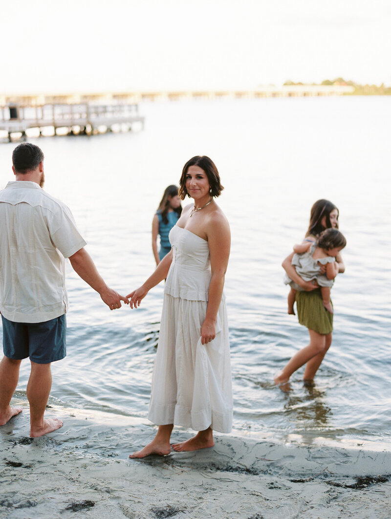 Family photo of Courtney Leigh and her husband and children walking in the water on the beach