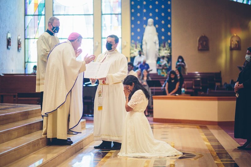 a Consecrated Virgin kneeling during a ceremony