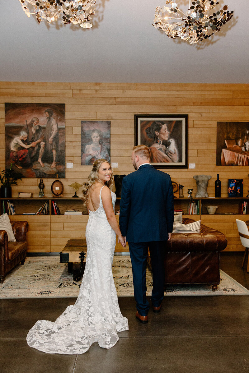 Bride and groom walking hand-in-hand through the Tampa River Center with romantic art deco details in the background