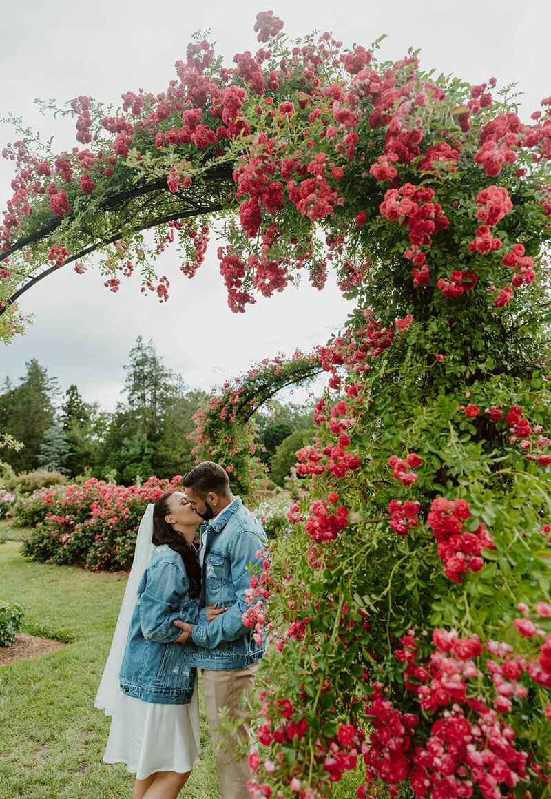 The groom and bride are kissing in the garden.