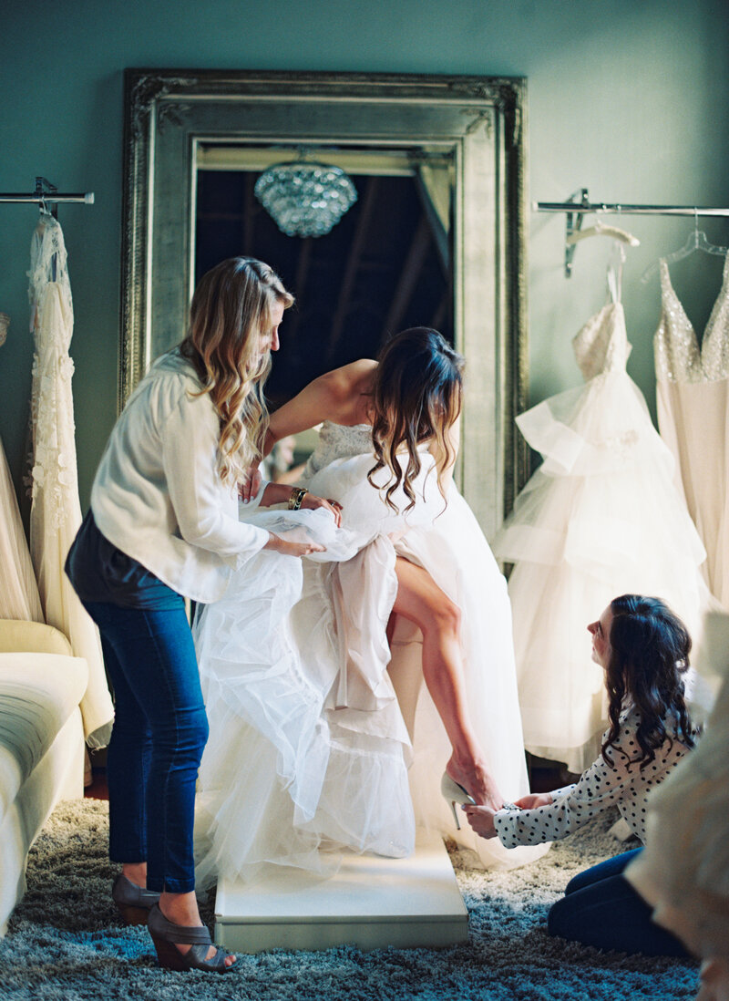 Engaged bride trying on wedding gown with her family