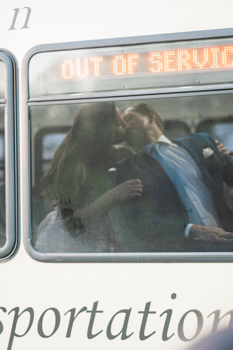 A couple kissing seen through the window of a bus