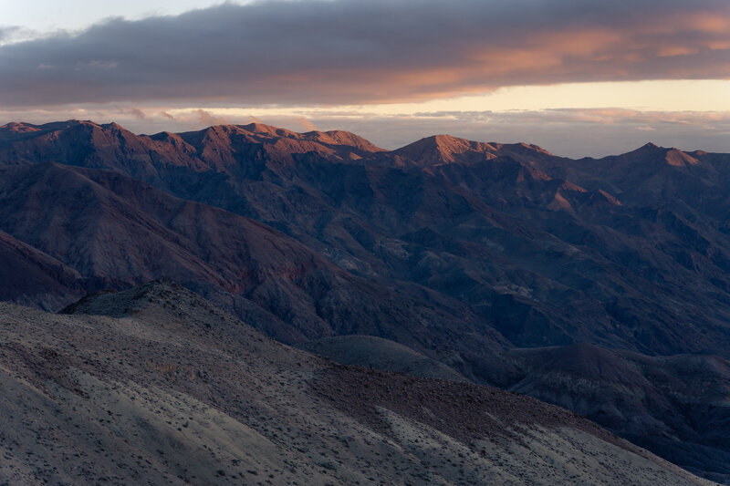 The sun setting over a rocky landscape in Death Valley