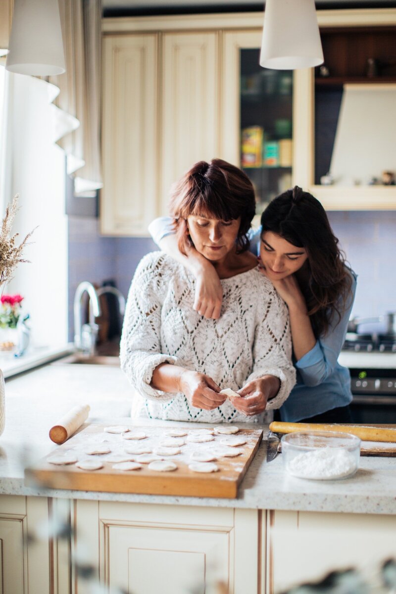 Woma and her adult daughter baking cookies in the kitchen