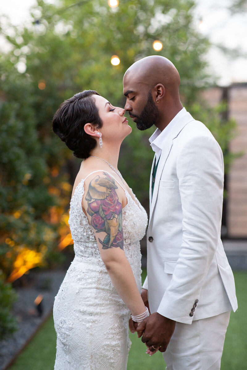 An Austin wedding photographer capturing a sweet moment of a bride and groom kissing in a beautiful garden.