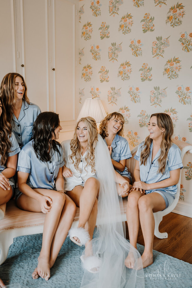 bride surrounded by bridesmaids sitting on a couch