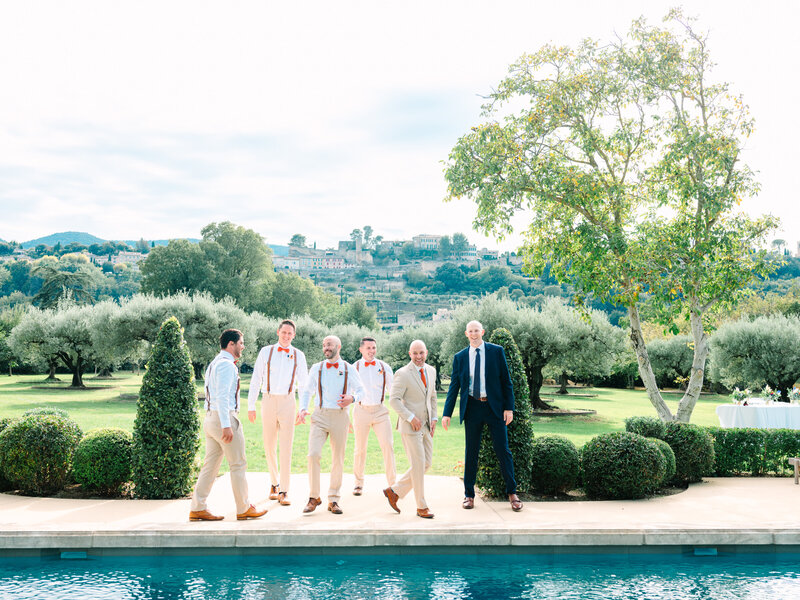 The Groom, Best Man, and Groomsmen Walking and Smiling by the Swimming Pool Overlooking the Provencal Village of Menerbes