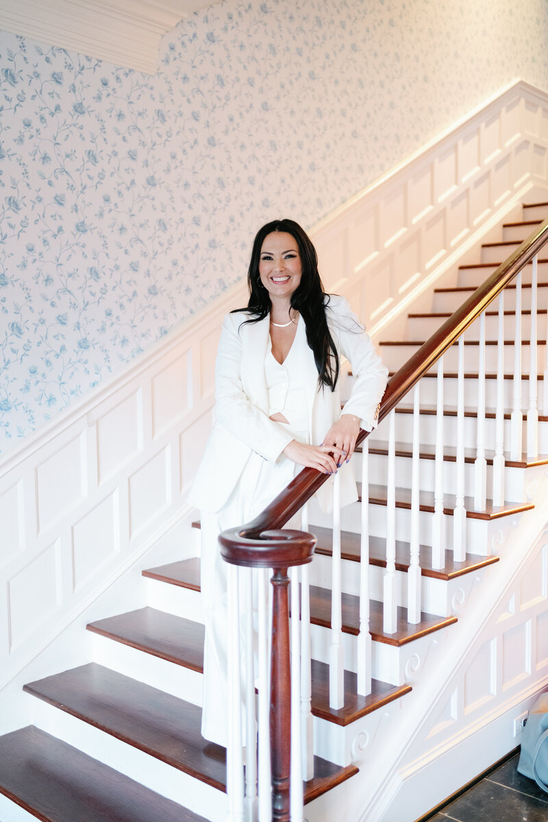 Owner and creative director Natasha sitting on chair with white background