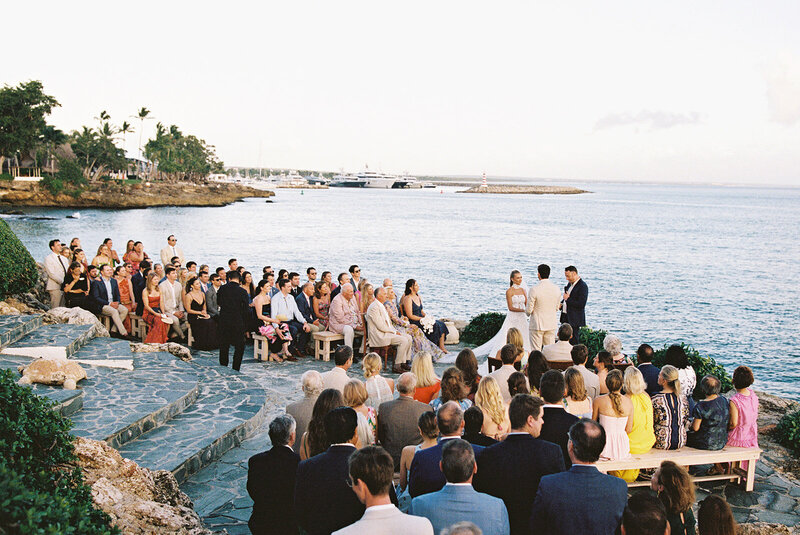 Oceanfront wedding ceremony at Casa de Campo Resort with guests gathered by the sea — elegant destination celebration captured by Asia Pimentel Photography.