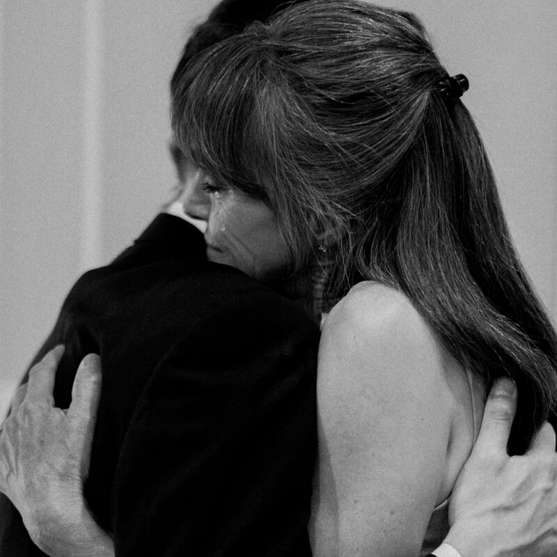 Black and white close up of groom hugging his mother