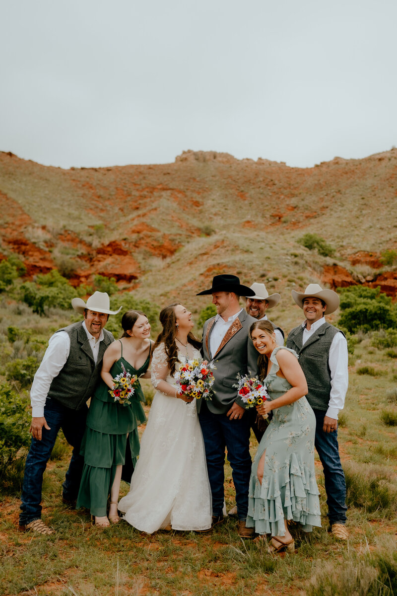 bride and groom celebrating with their bridal party at their ranch wedding