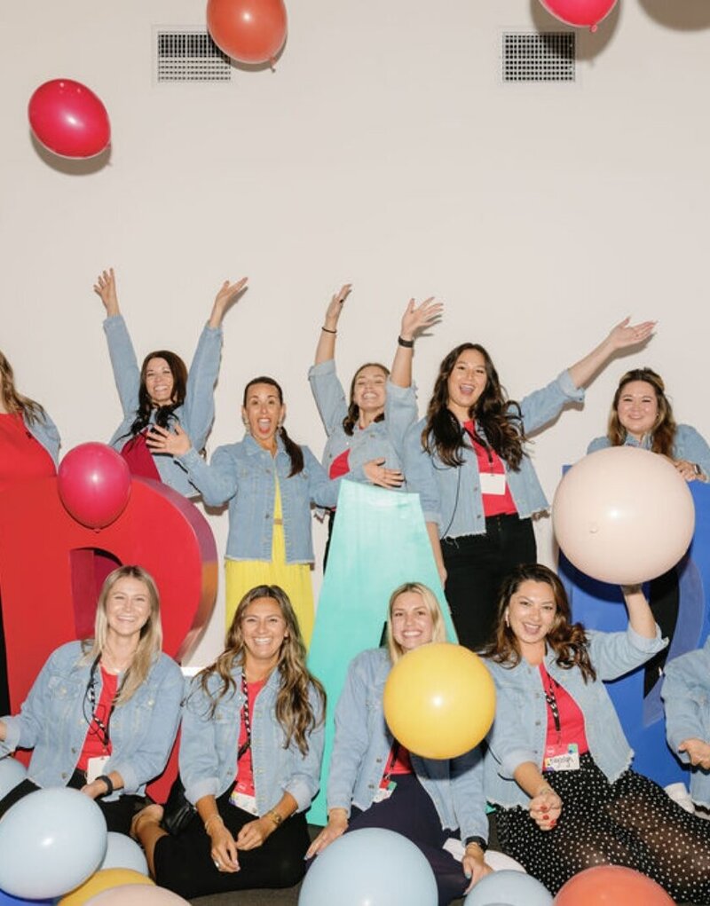 The Intertwined team cheering and throwing balloons for a team photo for RAD Camp.