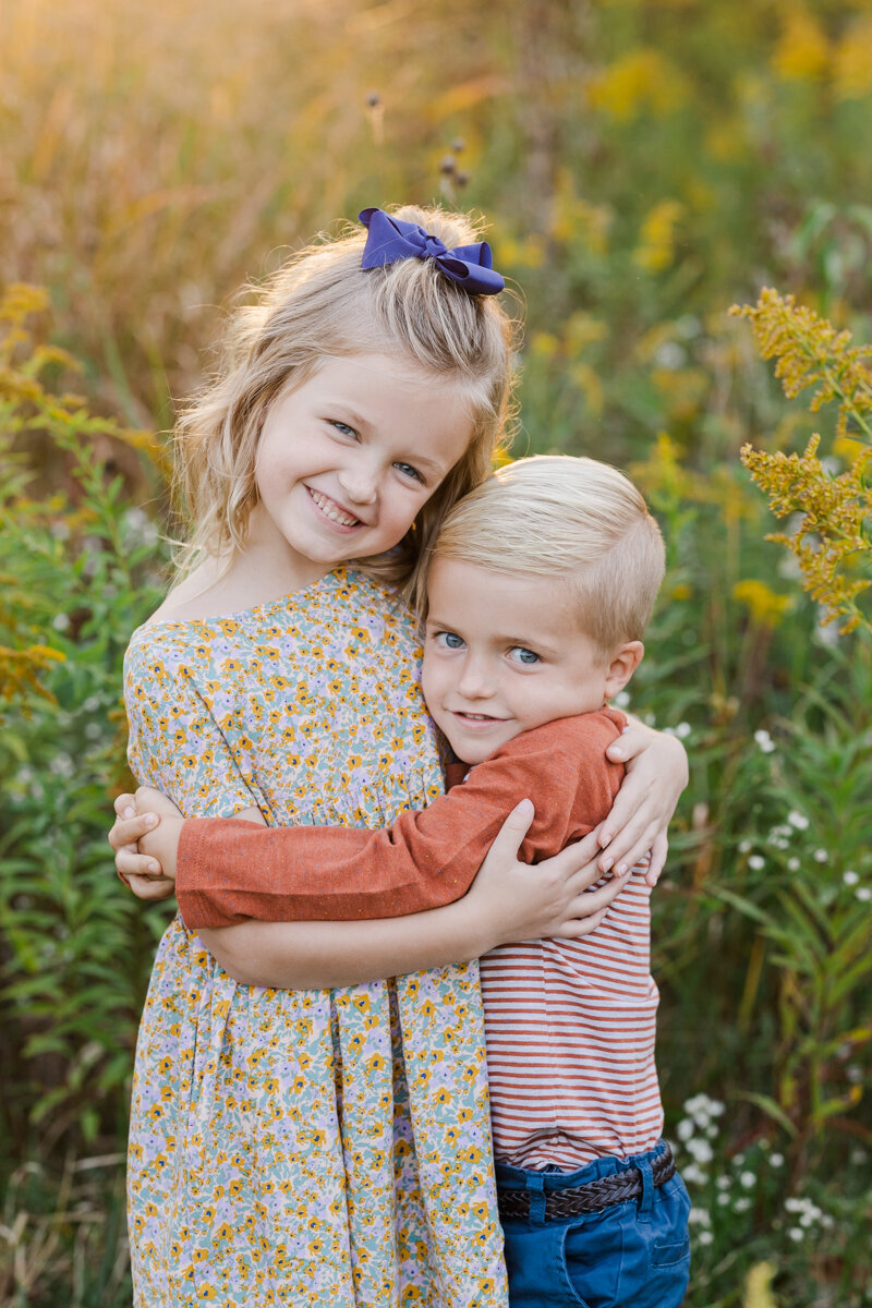 sunset golden light portrait in a field of children hugging and smiling