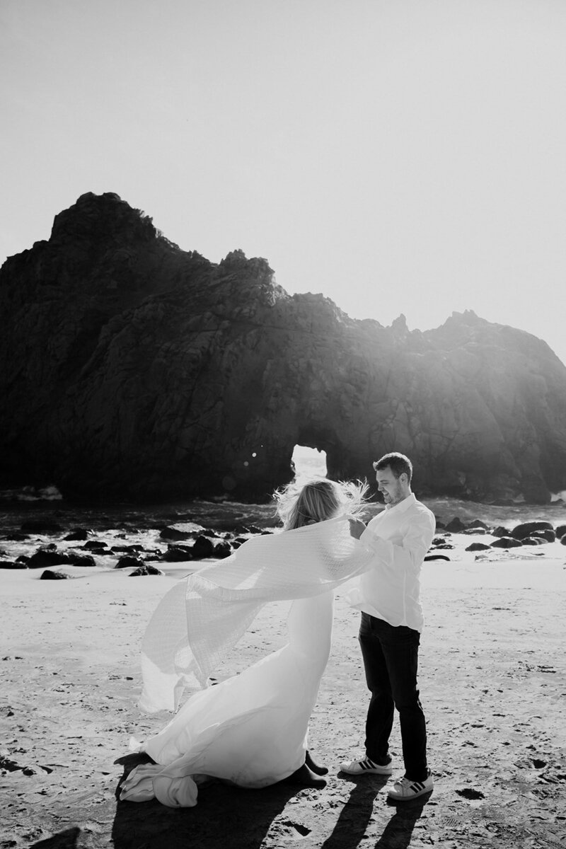 flowy wedding dress in wind at the beach