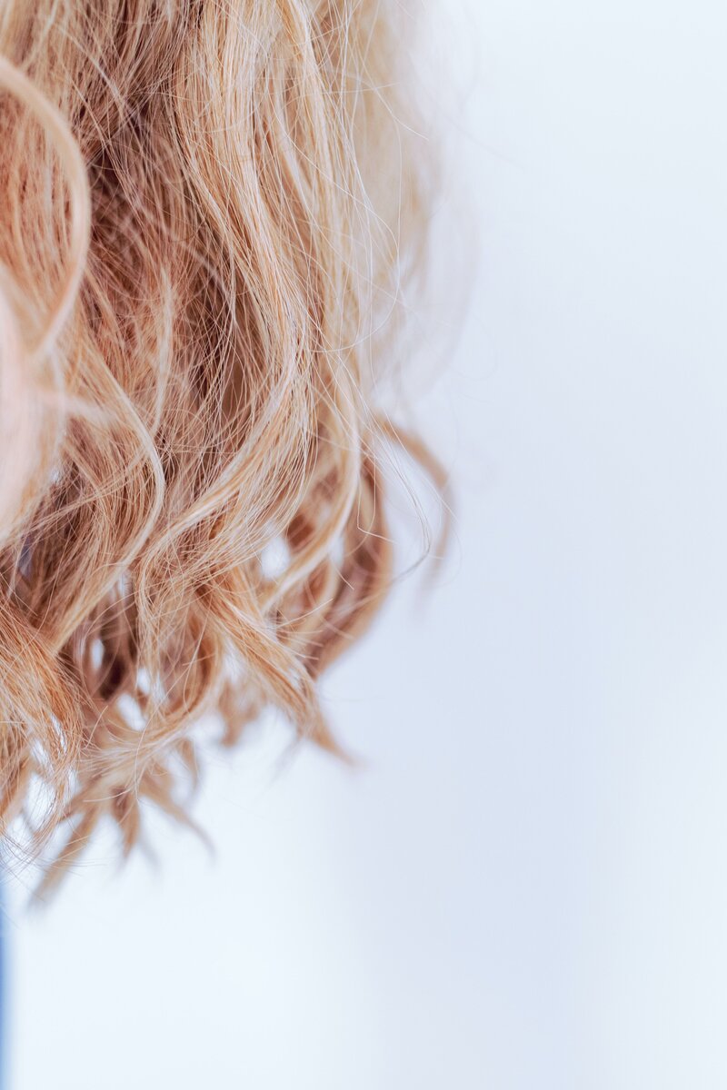 Thoughtful woman sitting with foil on hair at salon stock photo