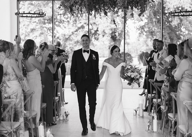 Bride and groom kissing in front of floral arch