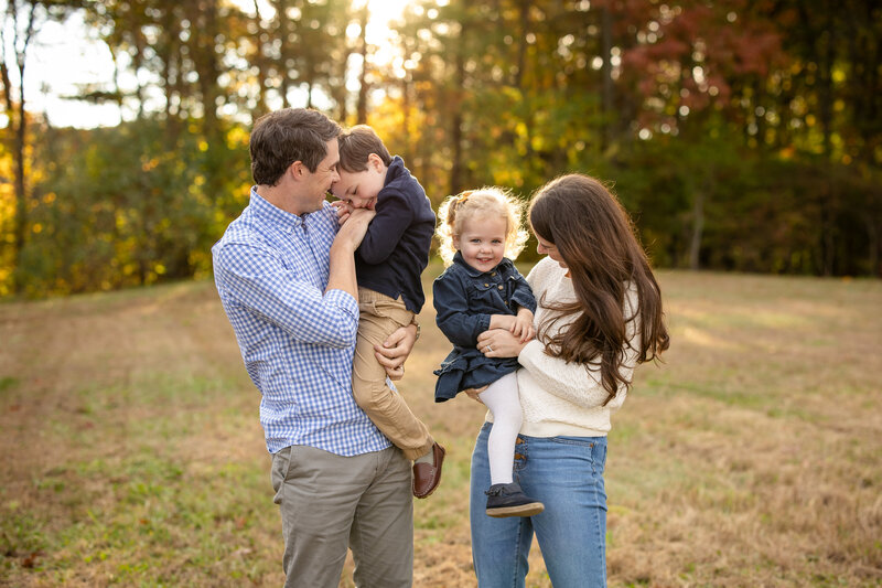 Family of four in wooded area laughing