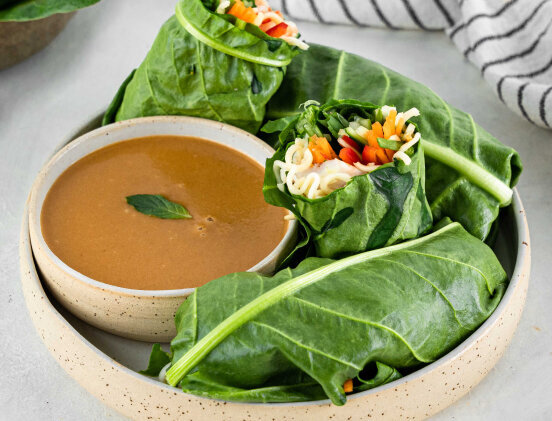 an image of an asian, vegan, noodle and veggies wraps with a soy and peanut sauce on the side