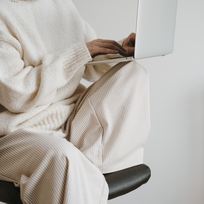 Laptop displaying the website design for social media managers on a minimalist desk with decorative items