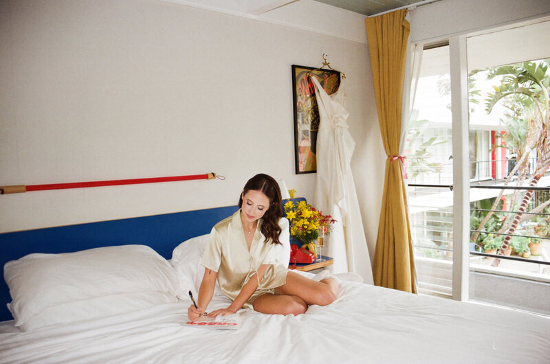 woman in robe writing on bed