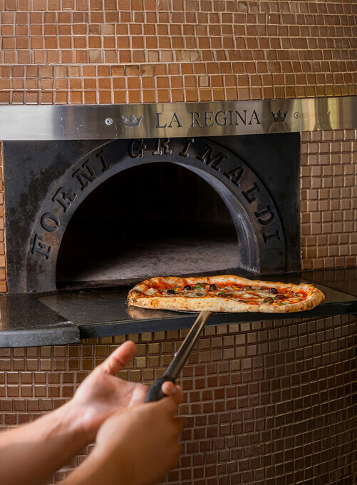Maquette de présentation de l'identité visuelle de Pizzolino, qui représente une ambiance gourmande et traditionnelle. L'image montre une pizza sortant du four du restaurant.