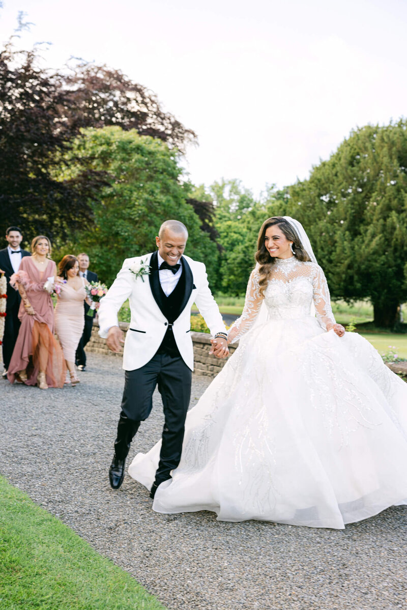 A wedding photo of a couple holding hands walking together at Luttrellstown Castle
