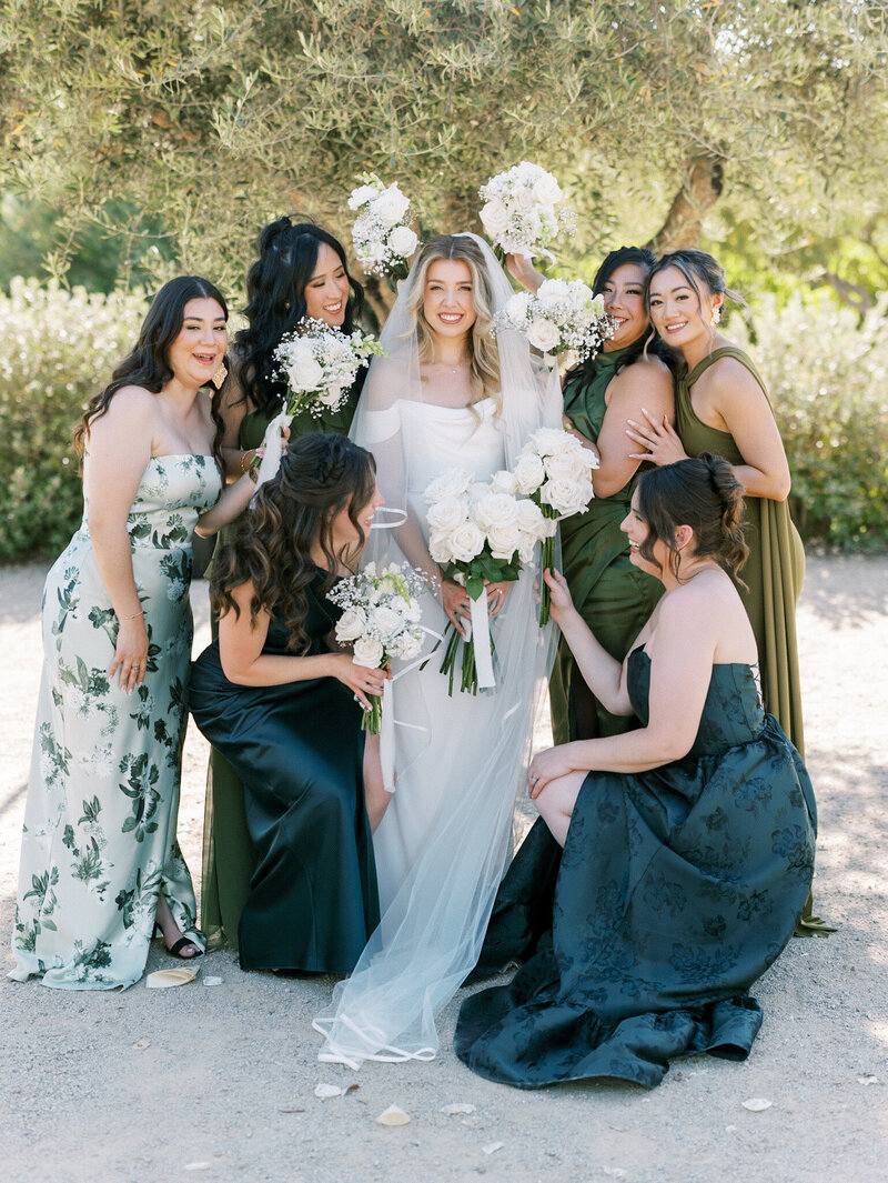  a couple walks hand-in-hand through a garden as flowers fall around them during their whimsical romantic style Bridgerton wedding day in Paso Robles, California.