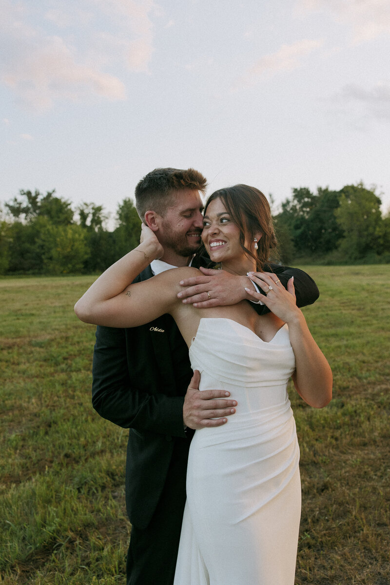 Bride and groom laughing during summer wedding at The BlueBelle Event Venue in Bemidji,MN